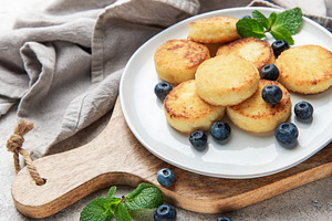 Syrniki cottage cheese pancakes with blueberries and mint, a Food & Drink Photo by Olena Rudo