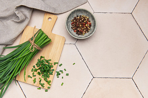 Fresh chives and peppercorns on rustic tile background, a Food & Drink Photo by Olena Rudo