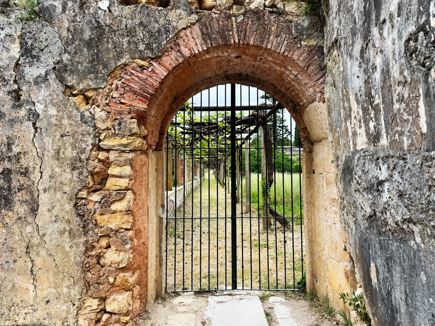 Stone archway with metal gate in Tomar castle, Portugal, leading to ...
