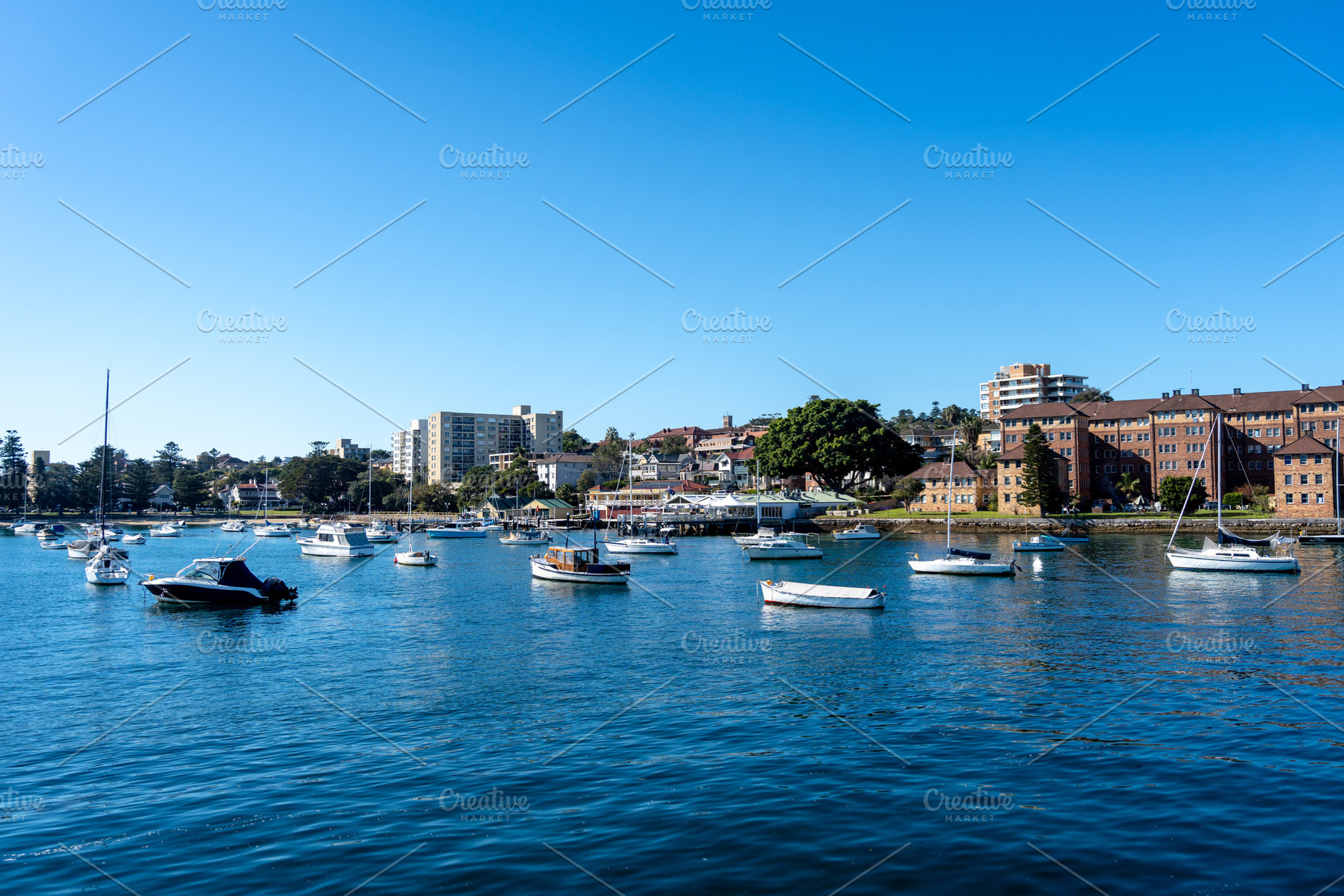 Manly Beach harbor with boats and waterfront buildings in Sydney, an Architecture Photo by GoodGoods