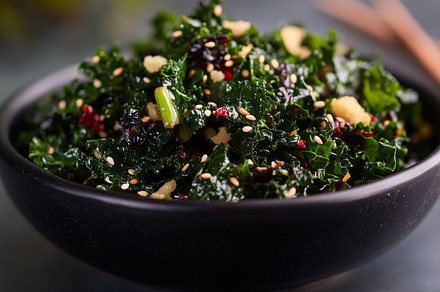 Kale salad with sesame seeds in black bowl, healthy food concept, a Photo by Dvoevnore photos
