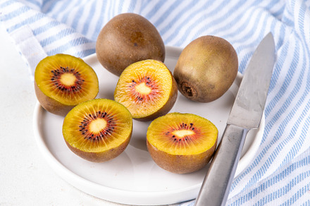 Red kiwi, Sweet bright red colored kiwi fruits, whole and sliced, a Food & Drink Photo by Rimma