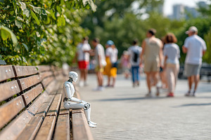 Humanoid figure sits on a bench while people walk by in a vibrant park setting, a Photo by AlyaAnd