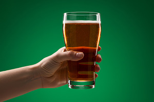 Hand holding a pint of beer against, a Food & Drink Photo by professorinc