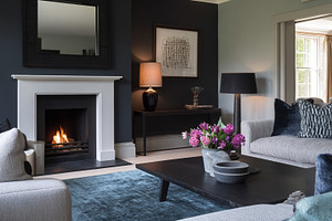 Modern living room interior featuring a lit fireplace, cozy sofa, a Photo by Studio ANNA