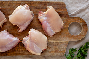 Raw Organic Boneless Skinless Chicken Thighs on a Wooden Board,, a Food & Drink Photo by LiudmylaChuhunova
