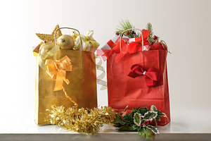 Red and gold gift bags with Christmas decorations on table, a Holiday Photo by Davizro's Market