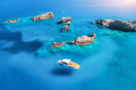 Aerial view of speed boat on blue sea at sunset in summer, a Transportation Photo by den-belitsky