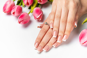 Woman showing french manicure and pink tulips on white backgroun, a Beauty & Fashion Photo by Olena Rudo