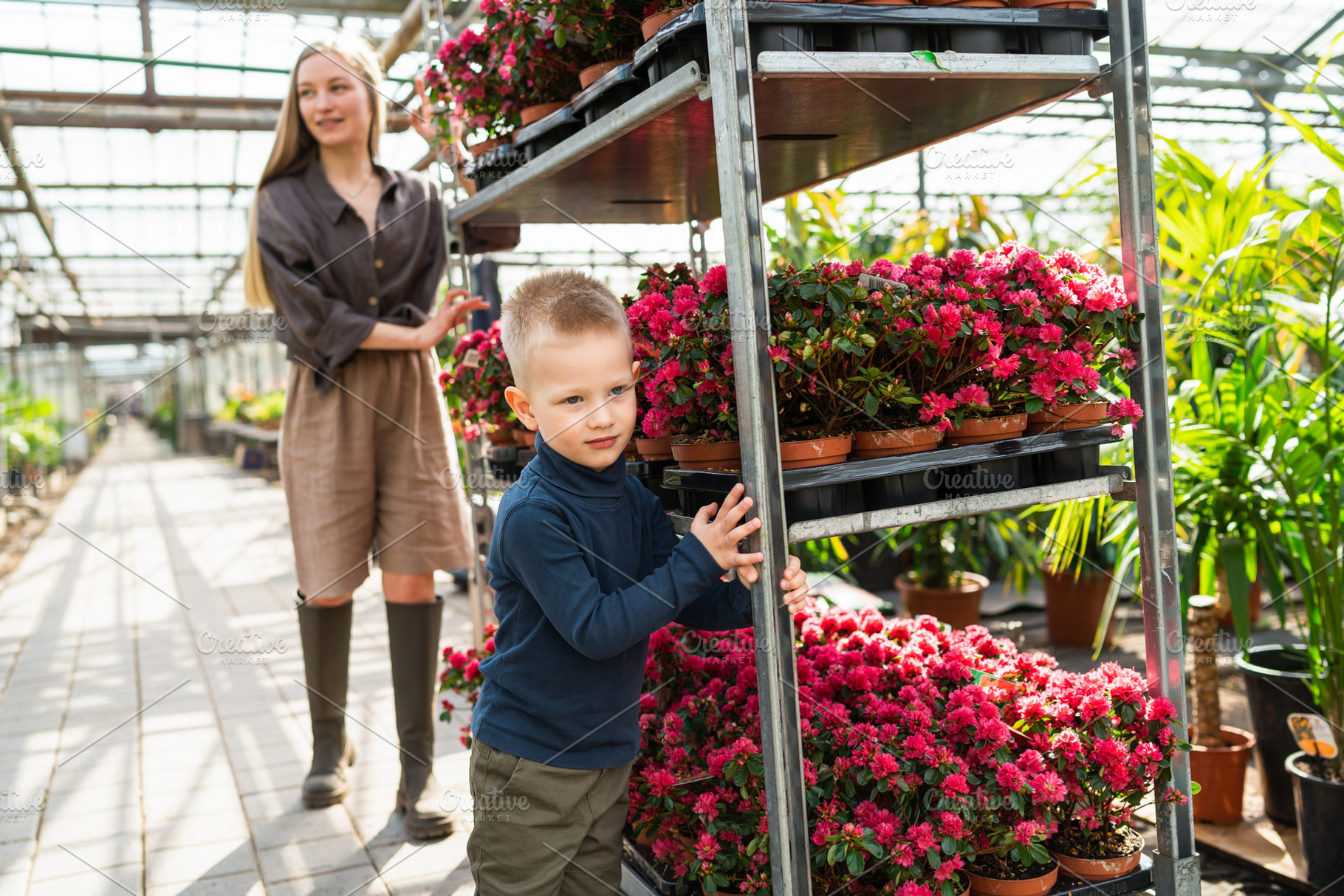 Mom and son push a cart with flowers, a Photo by Andrii Borodai
