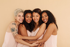 Four young smiling females embracing, a Person Photo by Artem Varnitsin