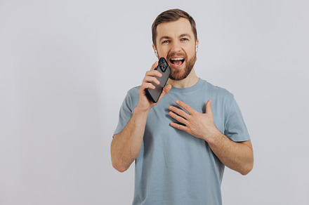 Happy bearded man dancing with earphones, listening music in hea, a Technology Photo by Cherkas Photography