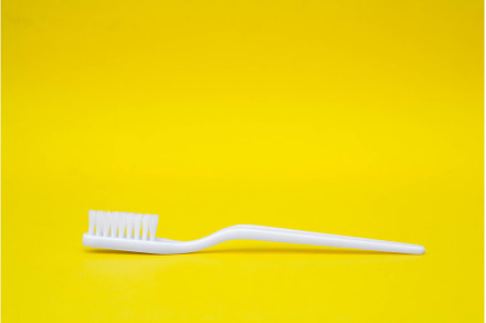 White toothbrush on yellow, a Health & Medical Photo by olhovyi_photographer