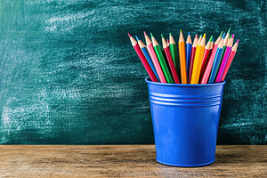Wooden colorful rainbow pencils in bucket on wooden table, a Photo by AlyaAnd