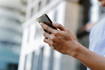 A man using a smartphone in an urban environment, representing m