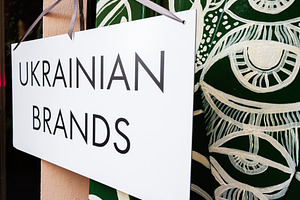 Sign promoting Ukrainian brands with eye catching art in the background, a Photo by AS photostudio