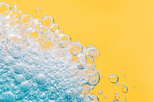 Close-up of blue detergent foam on yellow background, ideal for, a Photo by Dvoevnore photos