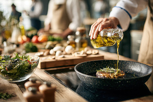 Chef pouring olive oil on steak in p, a Photo by Pixeness Studio