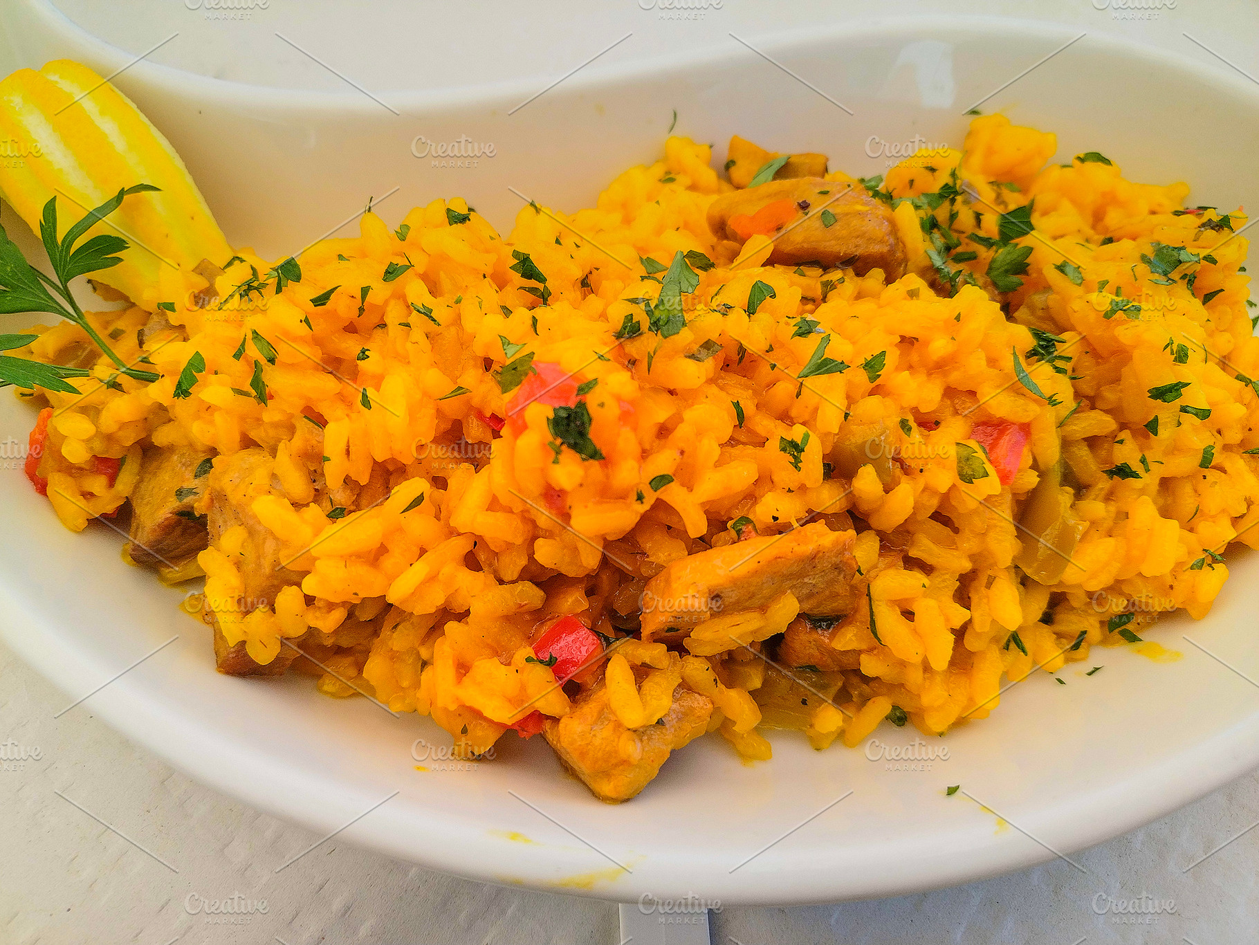 Saffron rice with chicken and vegetables in oval plate, a Food & Drink Photo by DanFLCreativo