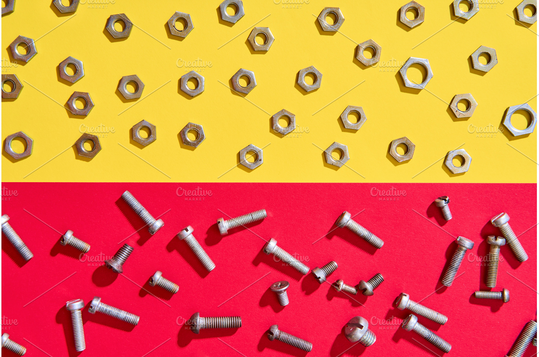 Screws and nuts on red yellow, an Industrial Photo by Gladkov photography