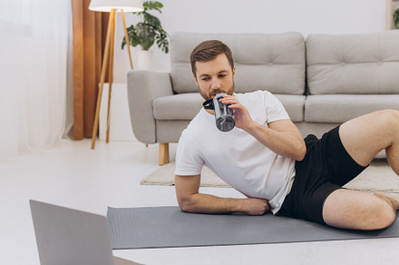 Handsome adult man using laptop and drinking water while having, a Sports & Recreation Photo by Cherkas Photography