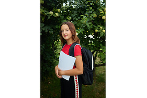 Teenage girl stands outside holding, a Nature Photo by IlliaBondarPhotography