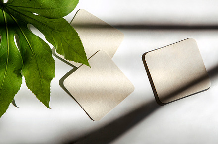 closup of coasters with shadows, a Photo by UN-BRANDED