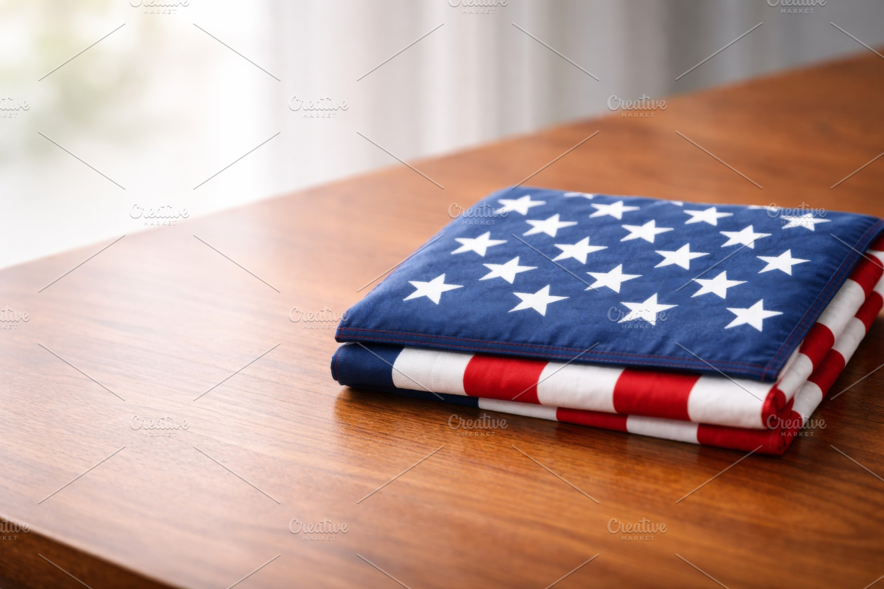 Folded American flag on wooden table, a Photo by Dvoevnore photos