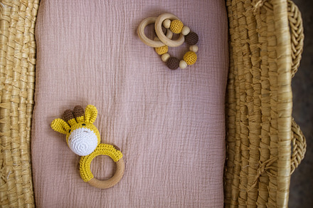 in a basket natural wooden knitted toys for a newborn. View from above