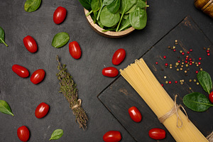 Flat lay of fresh spinach, cherry tomatoes, spaghetti, and spice, a Food & Drink Photo by ndanko