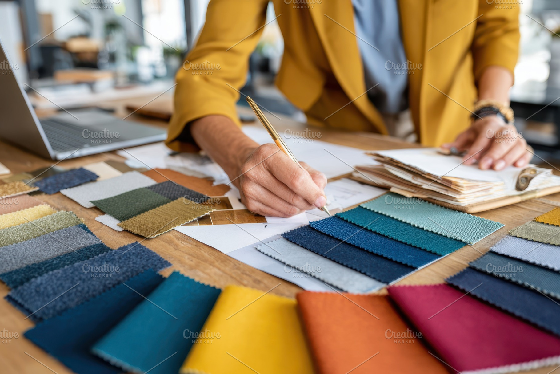 Designer selecting fabric swatches at worktable, an Arts & Entertainment Photo by AlyaAnd