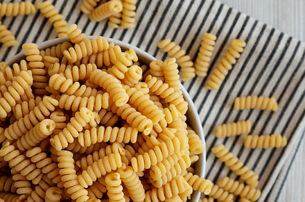 Uncooked Organic Dry Fusilli Pasta in a Bowl, top view. Flat lay, a Food & Drink Photo by LiudmylaChuhunova