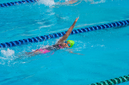 Swimmer child swims backstroke swimming style in a race swimming