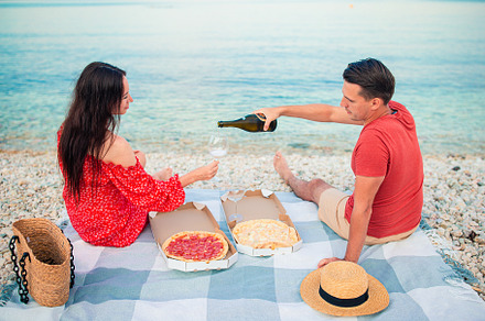 Lovely young couple having a picnic at the beach, a Person Photo by travnikovstudio