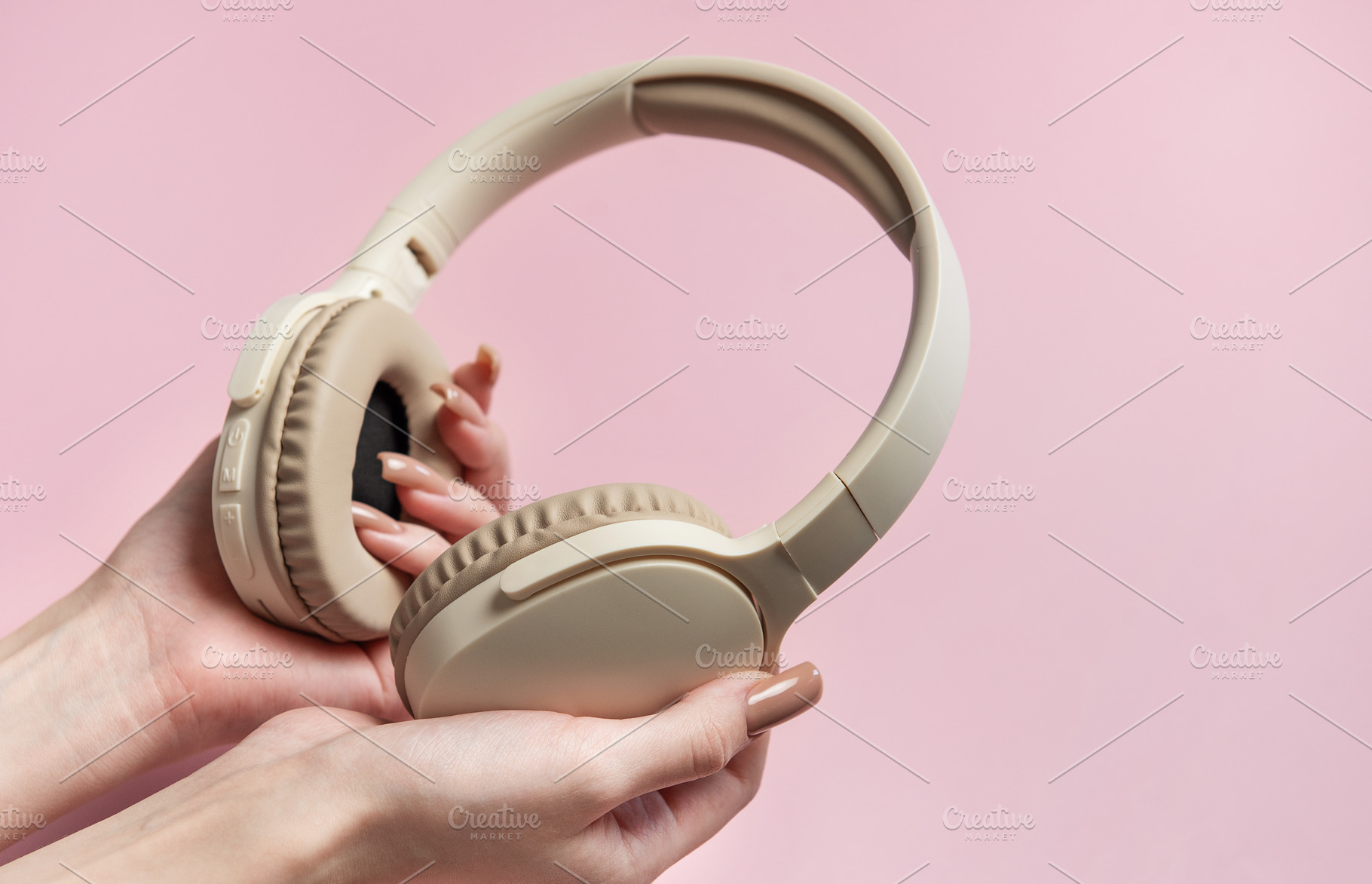 Woman holding wireless headphones on pink background, a Technology Photo by Olena Rudo