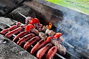 Barbecue with sausages and vegetables in a backyard., a Photo by AS photostudio