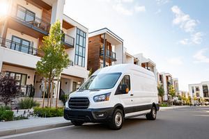 White delivery van in urban residential area, a Transportation Photo by AlyaAnd