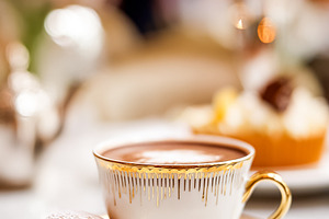 Hot chocolate and macaron served in an elegant porcelain cup wit, a Photo by Studio ANNA