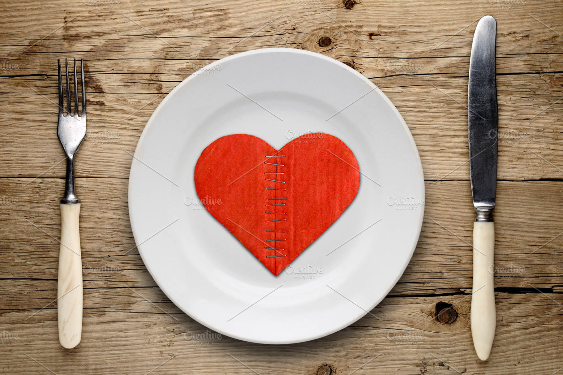 Broken cardboard heart on plate
