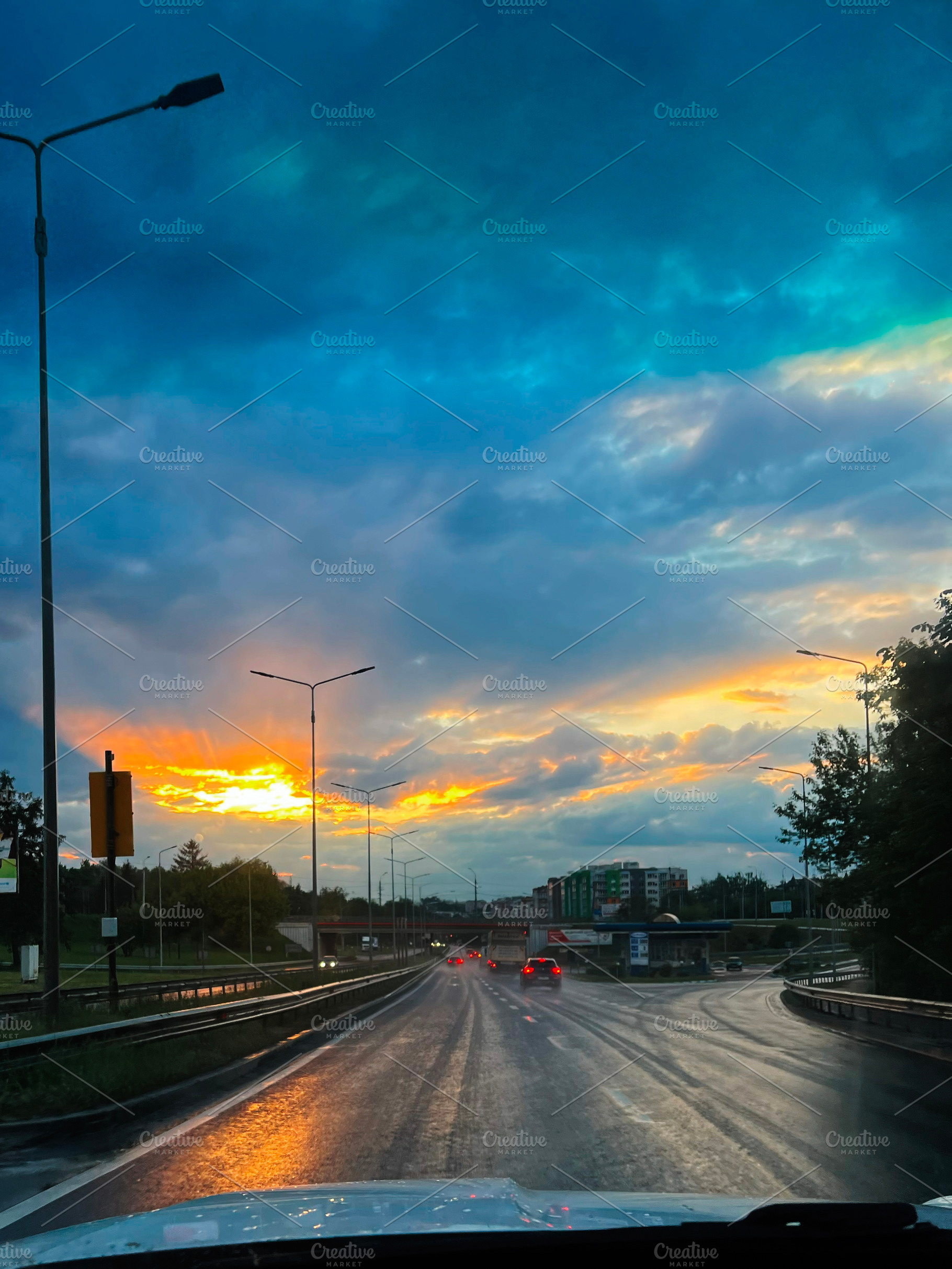 Scenic urban road at sunset with dramatic sky and illuminated street lights, a Photo by AS photostudio