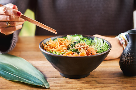 Woman eating poke bowl containing woman, eat, and food, a Food & Drink Photo by BodiaPhoto
