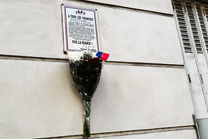Memorial bouquet and plaque on a Paris France wall serving as a patriotic tribu, a Photo by AS photostudio