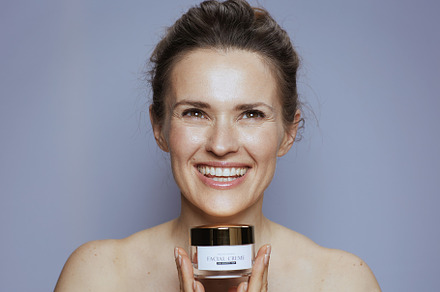 smiling modern female with cosmetic cream jar, a Person Photo by Alliance Images
