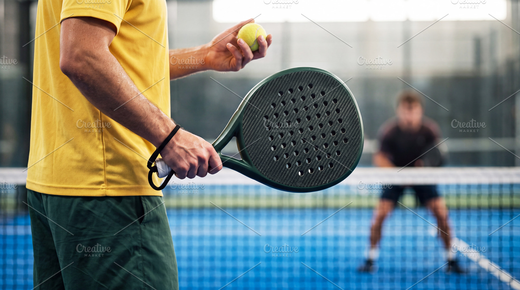 Close up of male padel player preparing to serve ball on court., a Sports & Recreation Photo by Volff