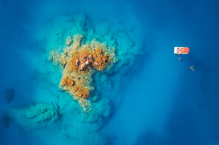 Boat in blue sea at sunset in summer. Aerial view, a Nature Photo by den-belitsky