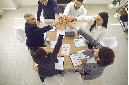 Happy sales team standing around an, a Person Photo by StudioRomantic