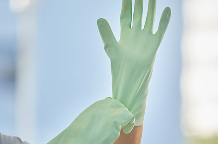 Woman, hands and gloves for cleaning home, hygiene and wellness. Spring cleaning, housekeeper or female cleaner getting ready for cleaning service to disinfect house to remove bacteria, germs or dust, a Photo by Peopleimages.com