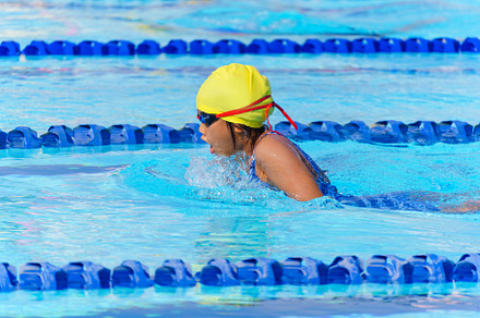 Swimmer child swims breaststroke swimming style in a race swimmi
