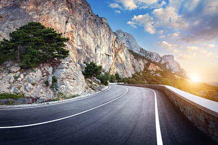 Asphalt road in mountains at sunset featuring road, landscape, and mountain, a Transportation Photo by den-belitsky