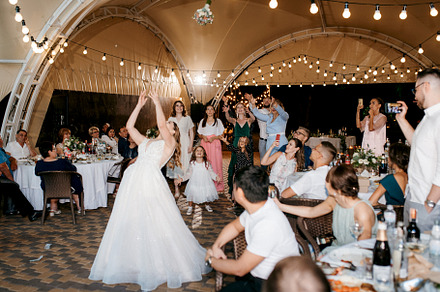 bride in a white dress throws a wedding bouquet